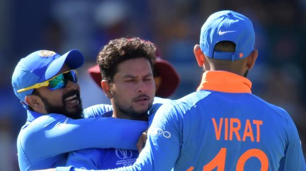 India's Kuldeep Yadav (C) celebrates with teammates.(AFP)