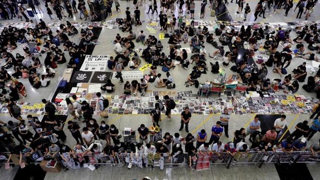 Anti-Extradition bill protesters distribute leaflets to passengers during a mass demonstration at the Hong Kong international airport, in Hong Kong.(REUTERS)