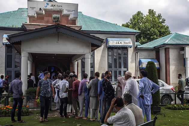 People wait in a queue outside J&K Bank in Srinagar on Tuesday. (ANI Photo) People wait in a queue outside J&K Bank in Srinagar on Tuesday. (ANI Photo)