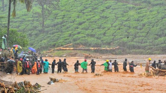 Rescuers help people to cross a flooded area after a landslide caused by torrential monsoon rains in Meppadi in Wayanad district in the southern Indian state of Kerala, India, August 9, 2019.(REUTERS)