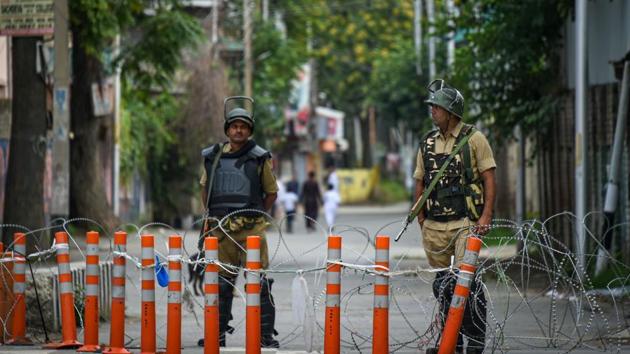 Security personnel stand guard during restrictions in Srinagar on August 12.(PTI)