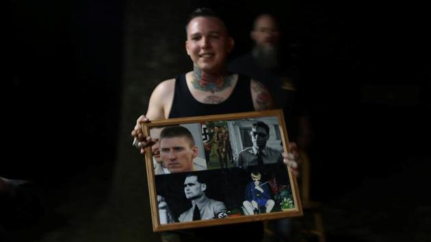 John Carollo, a member of the ShieldWall Network, holds up a photo montage of (clockwise from top left) Oklahoma City bomber Timothy McVeigh, Adolf Hitler, founder of the American Nazi Party George Lincoln Rockwell, Charleston church shooter Dylann Roof and Hitler’s deputy Rudolf Hess, while attending a party at a home outside Atkins, Arkansas. Carollo was recently charged with assault in connection with the beating of a gay man, according to police reports. (Jim Urquhart / REUTERS)