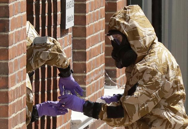 In this file photo specialist team members in military protective suits during Novichok nerve agent clean-up operations in Salisbury, England. British police confirmed Thursday Aug. 15, 2019, that a second police officer who responded to the March 2018 nerve agent attack in the English city of Salisbury was exposed to the agent Novichock, after tests confirmed the exposure.(AP File Photo)