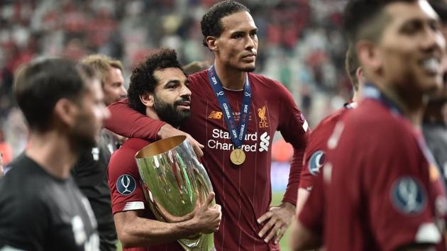 Liverpool's Egyptian midfielder Mohamed Salah and Liverpool's Dutch defender Virgil van Dijk pose with the trophy.(AFP)