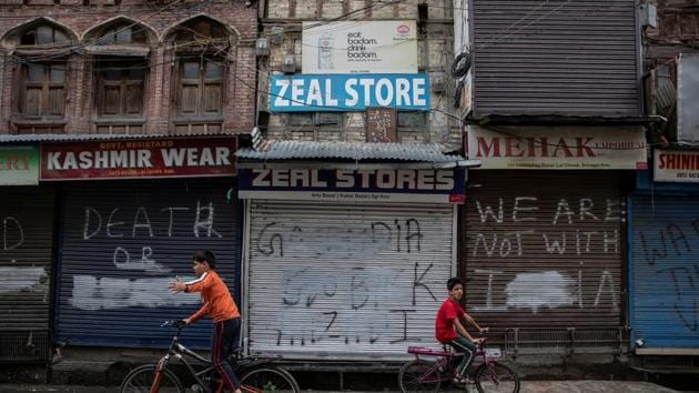 Kashmiri boys cycle in an empty street during restrictions after the scrapping of the special constitutional status for Kashmir. Many Indian publications (including HT) parachuted journalists into the region who filed stories on their return.(Reuters)