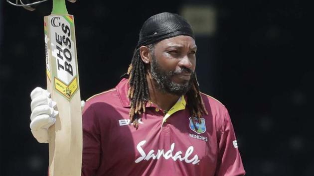 West Indies opener Chris Gayle raises his bat to the crowd after reaching a half century in third ODI against India.(AP)