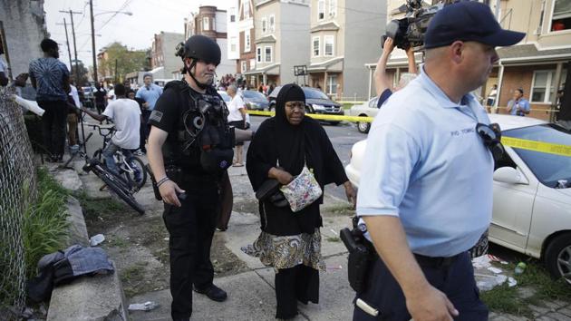 Philadelphia: Police officers escort a bystander away from the scene of a shooting, Wednesday, Aug. 14, 2019, in the Nicetown neighborhood of Philadelphia. AP/PTI(AP8_15_2019_000012B)(AP) Philadelphia: Police officers escort a bystander away from the scene of a shooting, Wednesday, Aug. 14, 2019, in the Nicetown neighborhood of Philadelphia. AP/PTI(AP8_15_2019_000012B)(AP)
