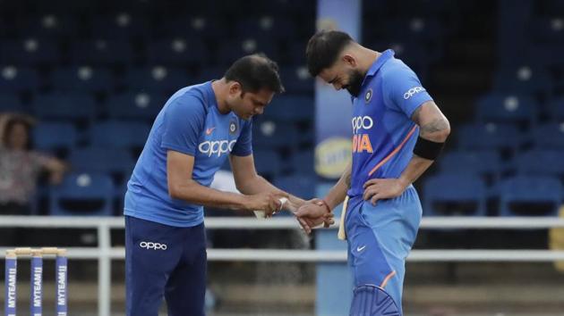 India captain Virat Kohli, right, grimaces after injuring his right thumb while batting a shot off West Indies wicketkeeper Kemar Roach during their third One-Day International cricket match in Port of Spain, Trinidad, Wednesday, Aug. 14, 2019.(AP)