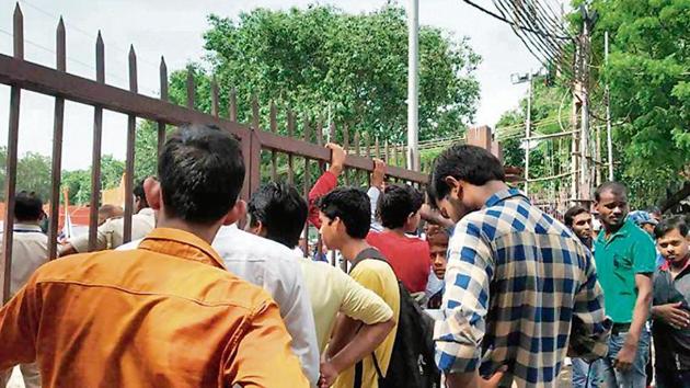 People wait outside the Red Fort premises after being stopped by the security personnel.(HT Photo)