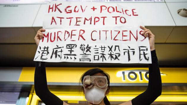A demonstrator holds a sign reading "HK Gov + Police Attempt To Murder Citizens" during a protest at the Hong Kong International Airport in Hong Kong, China. The increasingly violent protests have plunged the Chinese-ruled territory into its most serious crisis in decades, presenting Chinese leader Xi Jinping with one of his biggest challenges since he came to power in 2012. (Kyle Lam / Bloomberg) A demonstrator holds a sign reading "HK Gov + Police Attempt To Murder Citizens" during a protest at the Hong Kong International Airport in Hong Kong, China. The increasingly violent protests have plunged the Chinese-ruled territory into its most serious crisis in decades, presenting Chinese leader Xi Jinping with one of his biggest challenges since he came to power in 2012. (Kyle Lam / Bloomberg)