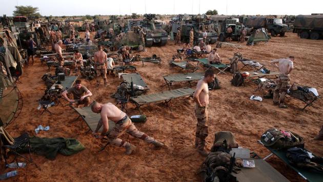 French soldiers of the Belleface Desert Tactical Group (GTD) set up a temporary operating base (TFOB) for the night in the Gourma region. On the first day of one mission, in 40 degree Celsius (104 F), the soldiers separated the women and children outside a thatched dome where camels chewed cud. They searched the men, took their smartphones and copied them onto a computer. One contained incriminating jihadist propaganda. (Benoit Tessier / REUTERS)
