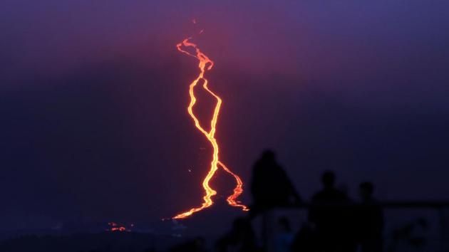 People look at lava erupting from the Piton de la Fournaise or the Peak of the Furnace flowing down the east-south-east face on the Indian Ocean island of Reunion. (Richard BOUHET / AFP) People look at lava erupting from the Piton de la Fournaise or the Peak of the Furnace flowing down the east-south-east face on the Indian Ocean island of Reunion. (Richard BOUHET / AFP)