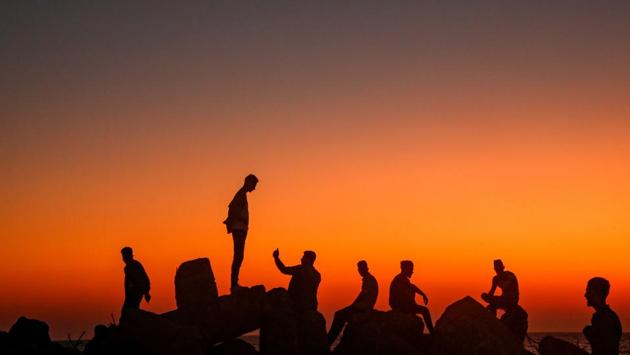 Palestinians sit and take pictures on the rocks by the Mediterranean in Gaza City, as people celebrate during the third day of Eid al-Adha,on August 13, 2019. (MOHAMMED ABED / AFP) Palestinians sit and take pictures on the rocks by the Mediterranean in Gaza City, as people celebrate during the third day of Eid al-Adha,on August 13, 2019. (MOHAMMED ABED / AFP)