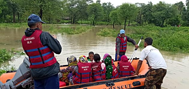 SDERF Personnel rescuing people from flood-affected areas at Shivpuri district on Friday.(ANI Photo)