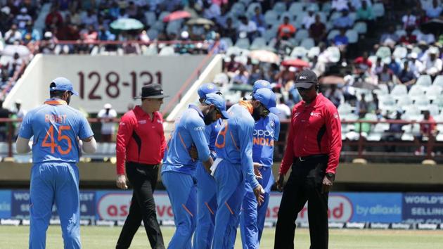 India's cricket players and umpires inspect the pitch.(AP)