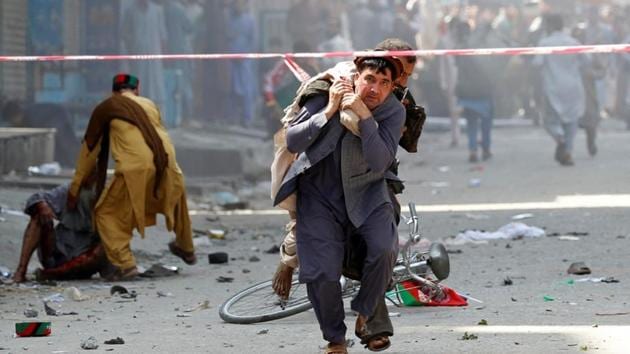 A man caries a wounded person to the hospital after a blast in Jalalabad, Afghanistan August 19, 2019.(REUTERS)