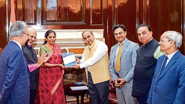 Finance minister Nirmala Sitharaman receives the report of the new direct tax code panel from its head Akhilesh Ranjan, a member of CBDT, and other members of the panel, in New Delhi on Monday.(PTI)