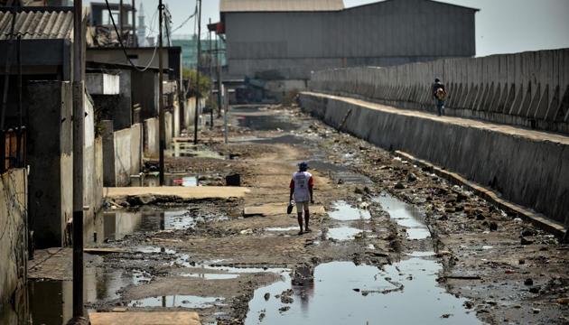 A man walks on a muddy road between abandoned warehouses and a giant sea wall in northern Jakarta. Being one of the fastest-sinking cities on earth, environmental experts warn that one third of it could be submerged by 2050 if current rates continue. Decades of uncontrolled and excessive depletion of groundwater reserves, rising sea-levels, and increasingly volatile weather patterns mean swathes of it have already started to disappear. (BAY ISMOYO / AFP) A man walks on a muddy road between abandoned warehouses and a giant sea wall in northern Jakarta. Being one of the fastest-sinking cities on earth, environmental experts warn that one third of it could be submerged by 2050 if current rates continue. Decades of uncontrolled and excessive depletion of groundwater reserves, rising sea-levels, and increasingly volatile weather patterns mean swathes of it have already started to disappear. (BAY ISMOYO / AFP)
