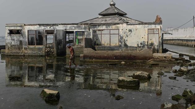 A man walks next to an abandoned submerged mosque. “You can see it with your own eyes,” said Andri. “When I was a kid I used to swim over there,” he added, motioning off in the distance. “Over time the water just kept getting higher and higher.” (BAY ISMOYO / AFP) A man walks next to an abandoned submerged mosque. “You can see it with your own eyes,” said Andri. “When I was a kid I used to swim over there,” he added, motioning off in the distance. “Over time the water just kept getting higher and higher.” (BAY ISMOYO / AFP)