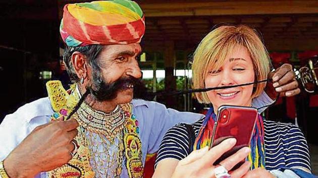 A tourist clicks selfie with an artist in Bikaner in 2017. (PTI Fil e Photo) A tourist clicks selfie with an artist in Bikaner in 2017. (PTI Fil e Photo)