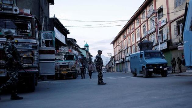 Security force personnel stand guard on a deserted road during restrictions after scrapping of the special constitutional status for Kashmir by the government, in Jammu ad Kashmir’s Srinagar.(Reuters File Photo)