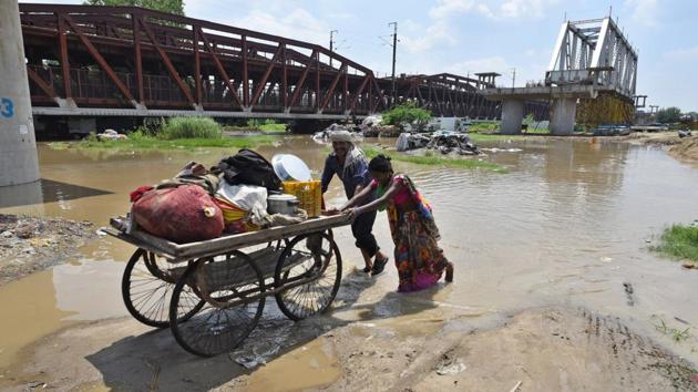 People take their belongings on a cart after their houses were submerged by the rising waters of the Yamuna River at Old Iron Bridge in New Delhi. The water level in the Yamuna continued to rise on Tuesday and is expected to touch a maximum height of 207.08m by Wednesday afternoon, officials of the flood and irrigation department said. The water level in the river had last breached the 207m mark during the 2013 floods, when it touched 207.32m. (Sanchit Khanna / HT Photo)