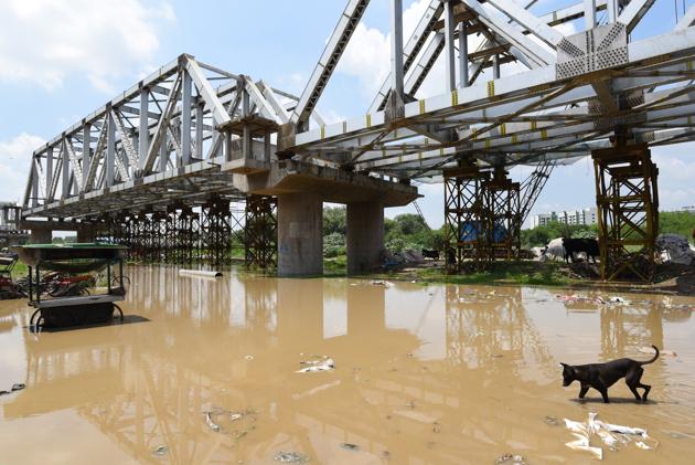 Vehicular traffic has already been suspended on the Old Iron Bridge since Monday, after the water level breached the danger mark of 205.33m. The Northern Railways too on Tuesday reduced the speed of trains, passing over the bridge, to 20km per hour. “We might have to temporarily suspend the movement of trains on the bridge if the water level increases beyond 206.4m,” said the spokesperson of North Railways. (Sanchit Khanna/HT PHOTO)