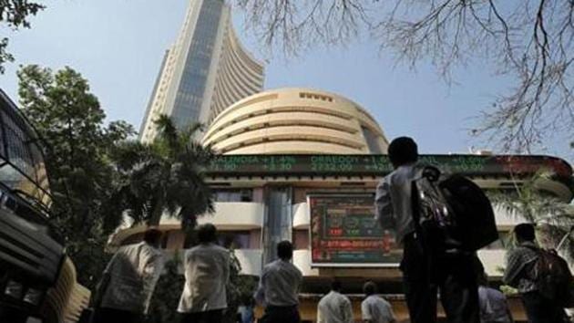 People look at a screen displaying the Sensex results on the facade of the Bombay Stock Exchange (BSE) building in Mumbai. (Reuters file photo) People look at a screen displaying the Sensex results on the facade of the Bombay Stock Exchange (BSE) building in Mumbai. (Reuters file photo)