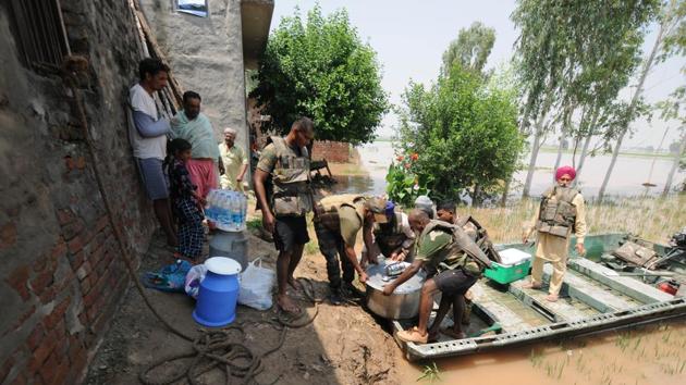 Army personnel carry food for villagers affected by severe floods, at Jamaliwala Village, in Punjab. (Pardeep Pandit / Hindustan Times) Army personnel carry food for villagers affected by severe floods, at Jamaliwala Village, in Punjab. (Pardeep Pandit / Hindustan Times)