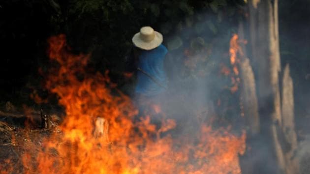 A man works in a burning tract of Amazon jungle as it is being cleared by loggers and farmers in Iranduba. Nearly 73,000 fires were recorded between January and August, compared to 39,759 in all of 2018, the embattled National Institute for Space Research (INPE) said. That is the highest number of forest fires for any year since 2013 and follows two years of declines. (Bruno Kelly / REUTERS)