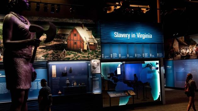 People view an exhibit about slavery at the Jamestown Settlement in  Virginia. The first of the two, the White Lion, arrived in Virginia in “the latter end of August” 1619, wrote John Rolfe, a wealthy English settler who was the husband of Pocahontas, whose father was a powerful native American tribal leader. The second ship, the Treasurer, arrived soon thereafter, dropping off a small group (Brendan Smialowski / AFP) 