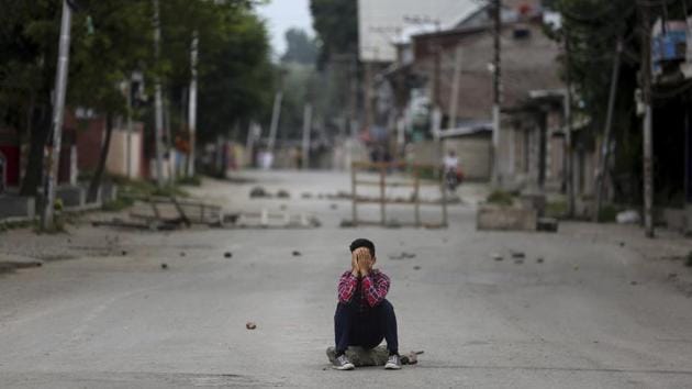 A protester covers his face as he sits on a rock during a protest. Just before midnight on August 4, Kashmir’s communications network went dark. Telephone landlines, cell phones, WiFi, broadband and cable TV were cut. (Altaf Qadri / AP) A protester covers his face as he sits on a rock during a protest. Just before midnight on August 4, Kashmir’s communications network went dark. Telephone landlines, cell phones, WiFi, broadband and cable TV were cut. (Altaf Qadri / AP)