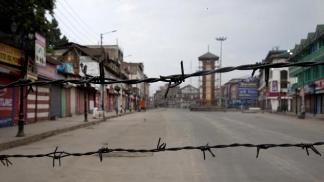 A deserted street is seen through barbed wire set up as a barricade during curfew in Srinagar. The streets of Kashmir Valley’s cities and towns, often reverberating with chants, are all but empty. The region is in the third week of an unprecedented lockdown that has largely kept its 7 million residents indoors. (Dar Yasin / AP) A deserted street is seen through barbed wire set up as a barricade during curfew in Srinagar. The streets of Kashmir Valley’s cities and towns, often reverberating with chants, are all but empty. The region is in the third week of an unprecedented lockdown that has largely kept its 7 million residents indoors. (Dar Yasin / AP)