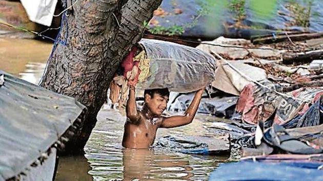 A man carries belongings through flood water in a residential area near the banks of the overflowing Yamuna river, in New Delhi, India, on Wednesday, August 21, 2019. Several low-lying areas along the Yamuna were today flooded as the water level in the river was flowing two metre above the danger mark and inching towards touching the highest level. (Raj K Raj/ Hindustan Times) A man carries belongings through flood water in a residential area near the banks of the overflowing Yamuna river, in New Delhi, India, on Wednesday, August 21, 2019. Several low-lying areas along the Yamuna were today flooded as the water level in the river was flowing two metre above the danger mark and inching towards touching the highest level. (Raj K Raj/ Hindustan Times)