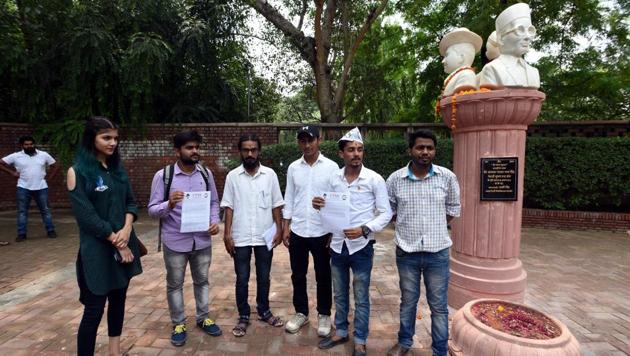 People gathered around a statue that has the busts of Veer Savarkar, Subhash Chandra Bose and Bhagat Singh at Arts Faculty in North Campus in New Delhi(Sonu Mehta/HT PHOTO)