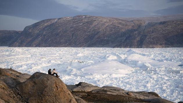 NYU student researchers sit on top of a rock overlooking the Helheim glacier in Greenland. Several scientists, such as NASA oceanographer Josh Willis, who is also in Greenland, studying melting ice from above, said what’s happening is a combination of man-made climate change and natural but weird weather patterns. Glaciers here do shrink in the summer and grow in the winter, but nothing like this year. (Felipe Dana / AP) NYU student researchers sit on top of a rock overlooking the Helheim glacier in Greenland. Several scientists, such as NASA oceanographer Josh Willis, who is also in Greenland, studying melting ice from above, said what’s happening is a combination of man-made climate change and natural but weird weather patterns. Glaciers here do shrink in the summer and grow in the winter, but nothing like this year. (Felipe Dana / AP)