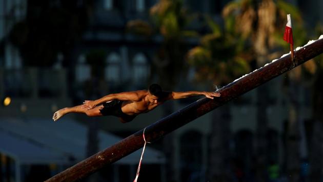 A competitor swipes off the “gostra”, a pole covered in lard, as he slips off the pole during the week-long celebrations of the religious feast of St Julian, patron of the town of St Julian’s, Malta. (Darrin Zammit Lupi / REUTERS) A competitor swipes off the “gostra”, a pole covered in lard, as he slips off the pole during the week-long celebrations of the religious feast of St Julian, patron of the town of St Julian’s, Malta. (Darrin Zammit Lupi / REUTERS)