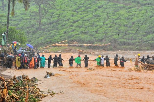 Rescuers help people to cross a flooded area after a landslide caused by torrential monsoon rains in Meppadi in Wayanad district in Kerala, August 9, 2019.(Reuters file photo)