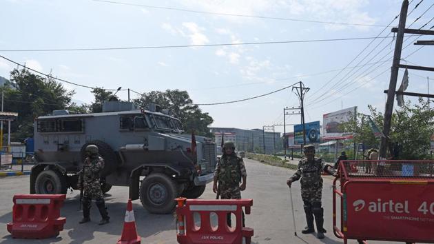 Security personnel stand guard near barricades in Srinagar.(Waseem Andrabi /HT PHOTO)