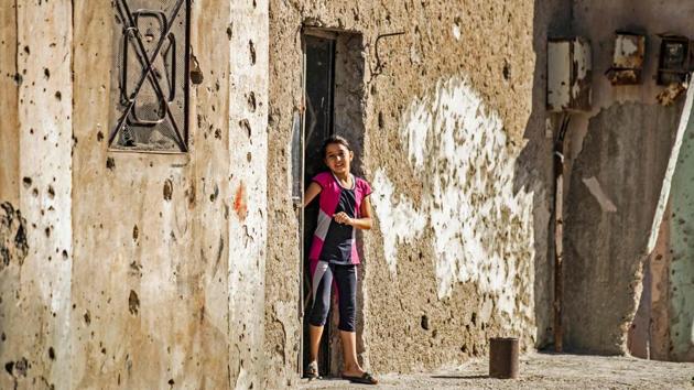 A child stands at by a bullet riddled wall in the northern Syrian city of Raqa, the former Syrian capital of the Islamic State (IS) group. (Delil Soulieman / AFP) A child stands at by a bullet riddled wall in the northern Syrian city of Raqa, the former Syrian capital of the Islamic State (IS) group. (Delil Soulieman / AFP)
