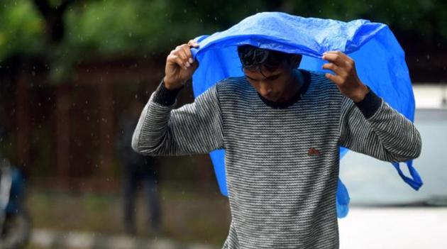 A man covers himself with a plastic sheet during rain, in New Delhi (Amal KS / Hindustan Times) A man covers himself with a plastic sheet during rain, in New Delhi (Amal KS / Hindustan Times)