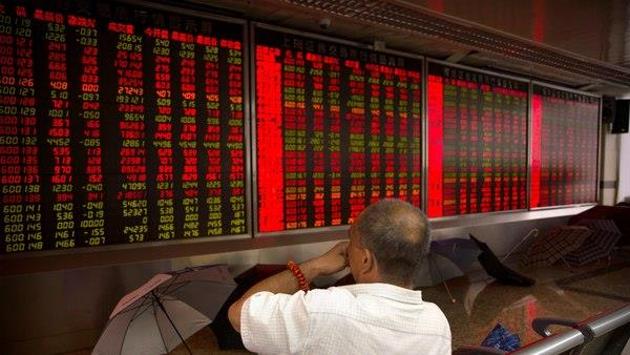 A Chinese investor monitors stock prices at a brokerage house in Beijing. Bond markets in advanced economies have been signalling rising stress for some time. (AP Photo) A Chinese investor monitors stock prices at a brokerage house in Beijing. Bond markets in advanced economies have been signalling rising stress for some time. (AP Photo)