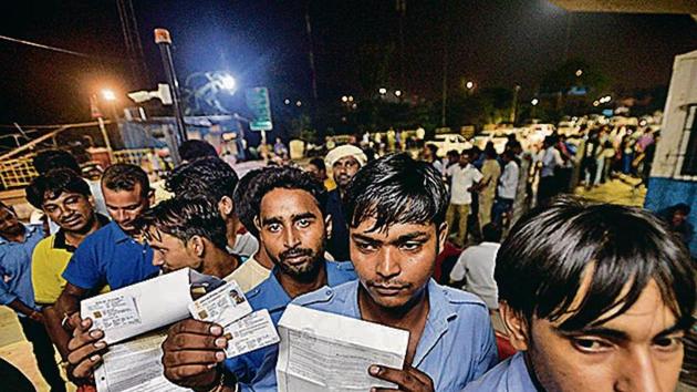 People queued to get RFID Cards at Ghazipur toll booth hold up their documents in New Delhi(Biplov Bhuyan/ Hindustan Times)
