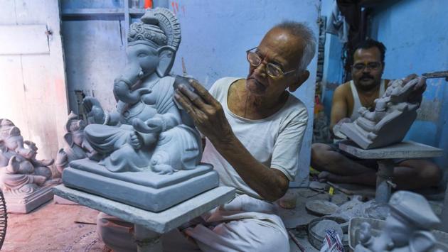 Some, like 87-year-old Pandurang Hazare (L), have been in the trade for far longer. This workshop, which has employed five generations of the family beginning with Hazare’s father, specialises in eco-friendly idols using clay –a material particularly vulnerable to the perils of monsoon. (Satish Bate / HT Photo) Some, like 87-year-old Pandurang Hazare (L), have been in the trade for far longer. This workshop, which has employed five generations of the family beginning with Hazare’s father, specialises in eco-friendly idols using clay –a material particularly vulnerable to the perils of monsoon. (Satish Bate / HT Photo)