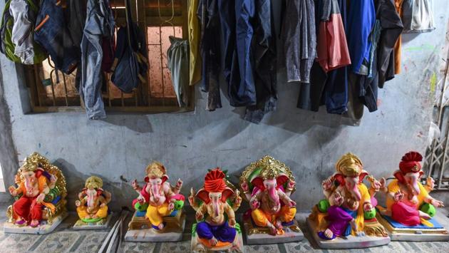 Clay idols of the enthroned Ganapati, with luxuriantly plump bellies grace the floor of a workshop while the clothes of workers hand on a wall adjacent. These past few weeks have been spent in overdrive, trying to catch up with the progress that was washed away. (Satish Bate / HT Photo) Clay idols of the enthroned Ganapati, with luxuriantly plump bellies grace the floor of a workshop while the clothes of workers hand on a wall adjacent. These past few weeks have been spent in overdrive, trying to catch up with the progress that was washed away. (Satish Bate / HT Photo)
