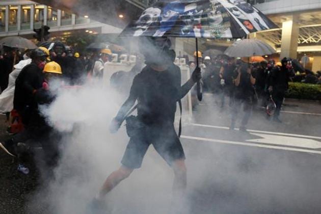 Demonstrators react to tear gas as they clash with riot police during anti-extradition protest in Hong Kong, China.(Reuters Photo)