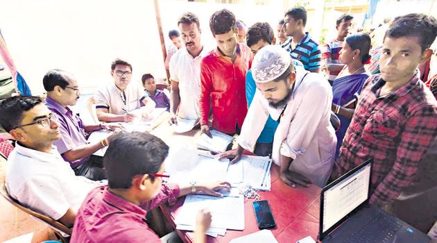 Assam state National Register of Citizens (NRC) officials check documents of residents after their names were not included in the citizens register in Nagaon district.(PTI)