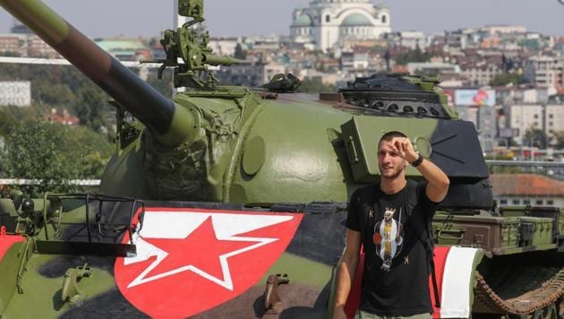 A Red Star Belgrade fan poses in front of the Soviet-made T-55 main battle tank.(REUTERS)