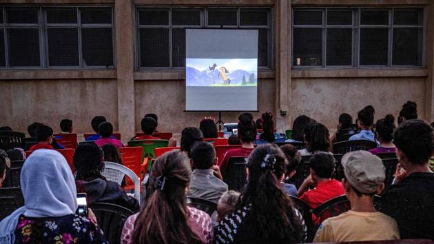 Children attend a film screening as part of the “Komina Film” initiative, in the village of Shaghir Bazar, in the Kurdish-populated areas of Hasakeh province, Syria. In a schoolyard of rural northeastern Syria, boys and girls broke out into giggles watching Charlie Chaplin’s pranks and animated films, a rare treat thanks to a mobile cinema roving through the country’s northeast countryside. (Delil Souleiman / AFP) Children attend a film screening as part of the “Komina Film” initiative, in the village of Shaghir Bazar, in the Kurdish-populated areas of Hasakeh province, Syria. In a schoolyard of rural northeastern Syria, boys and girls broke out into giggles watching Charlie Chaplin’s pranks and animated films, a rare treat thanks to a mobile cinema roving through the country’s northeast countryside. (Delil Souleiman / AFP)