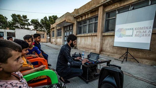 A Komina Film volunteer prepares a screening. The mobile cinema, says Hinde, aims to introduce young children to something he missed out on as a schoolboy. “When we were kids, the cinema was that dark place,” he said. In primary school, he and others were taken to see films inappropriate for their age and in substandard conditions, he recalled. It was only later that he discovered “the truth and beauty of cinema”. (Delil Souleiman / AFP) A Komina Film volunteer prepares a screening. The mobile cinema, says Hinde, aims to introduce young children to something he missed out on as a schoolboy. “When we were kids, the cinema was that dark place,” he said. In primary school, he and others were taken to see films inappropriate for their age and in substandard conditions, he recalled. It was only later that he discovered “the truth and beauty of cinema”. (Delil Souleiman / AFP)